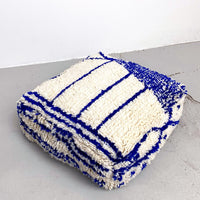 Pouf berbère marocain Azilal écru à motifs bleu majorelle