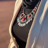 Collier artisanal en métal pour une apparence classe et chic, couleur argenté et rouge.
